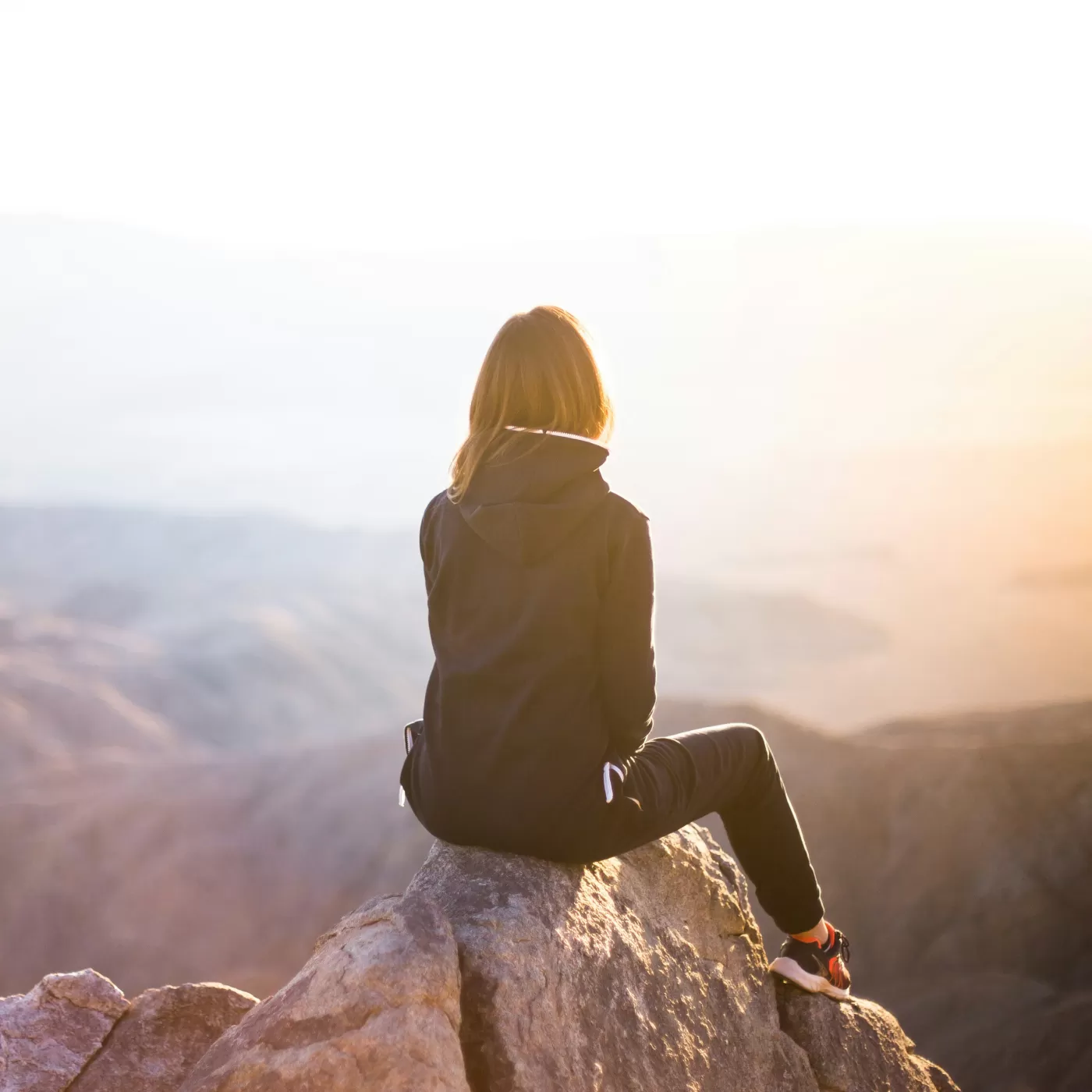 Image of a woman sitting on top of a mountain